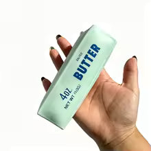 Hand squeezing the turquoise butter stick squishy stress ball
